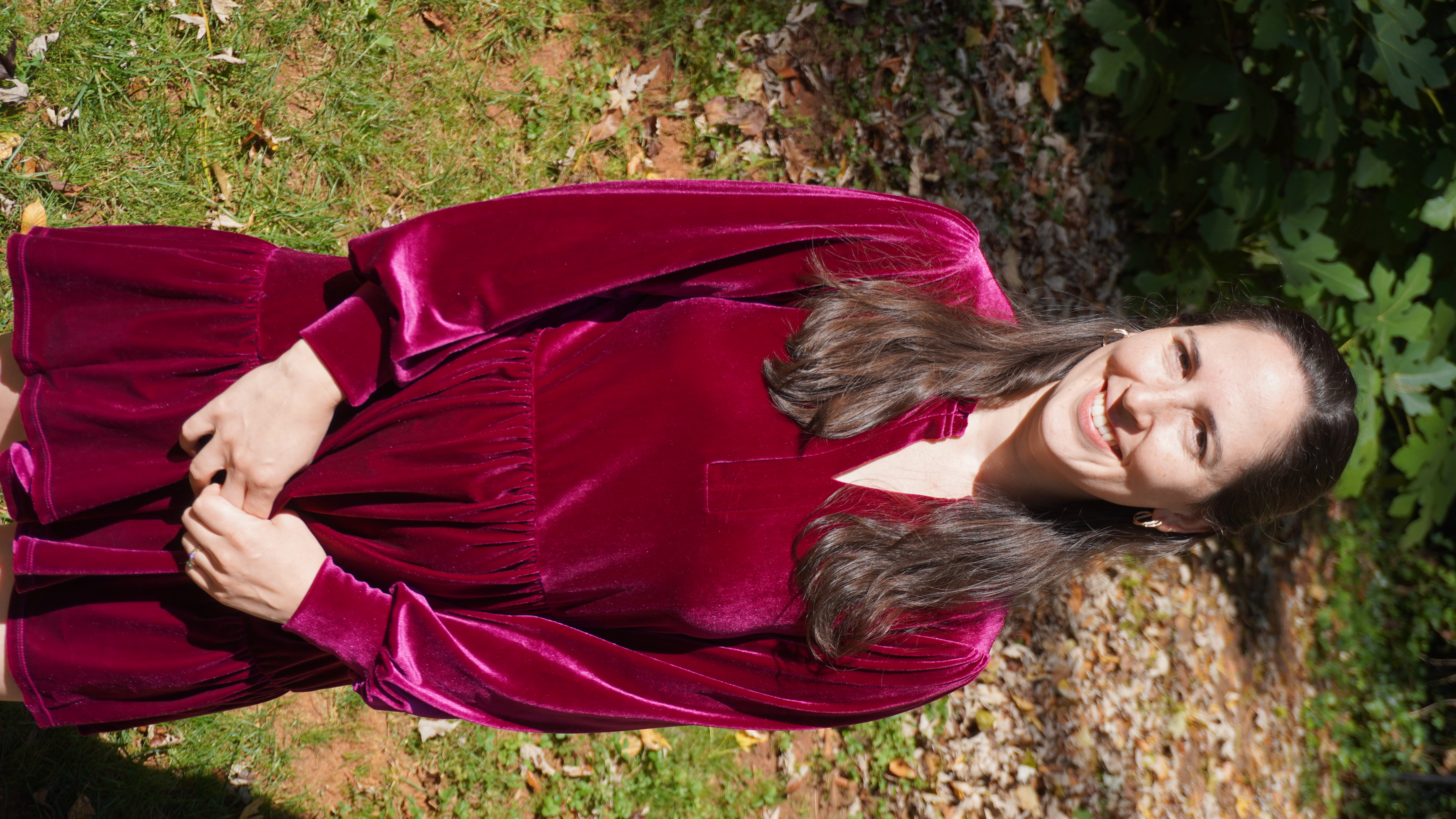 Woman with dark hair and red dress smiling